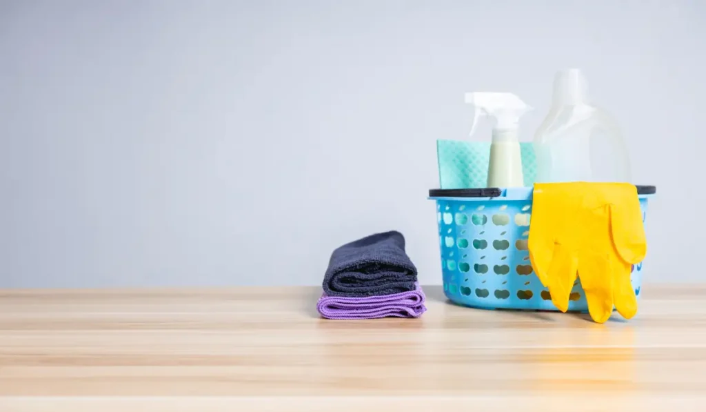 stock image of cleaning supplies on a wood countertop