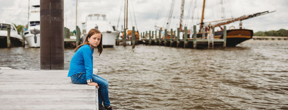 070126 accreditation planter post A girl sits on a dock at the Chestertown Marina.